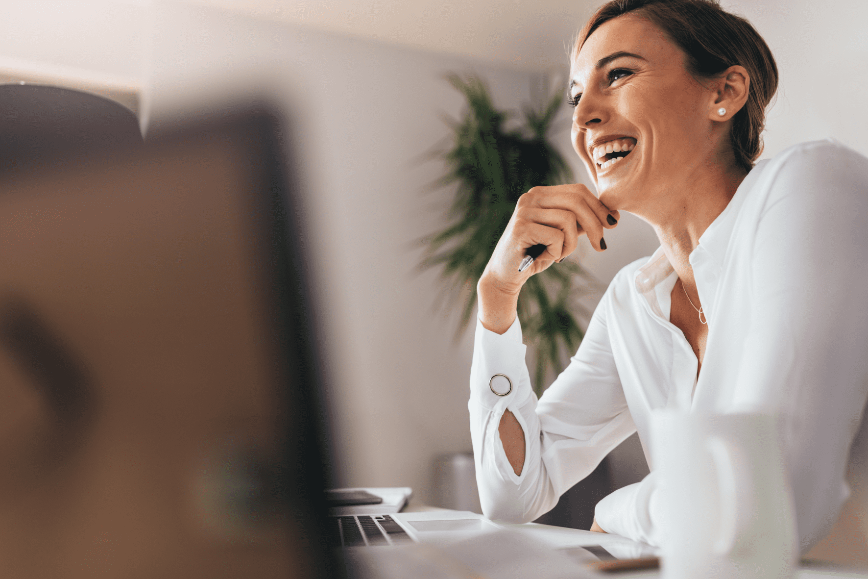 Fix des im coworking space, es sitzt eine lachende Frau am PC